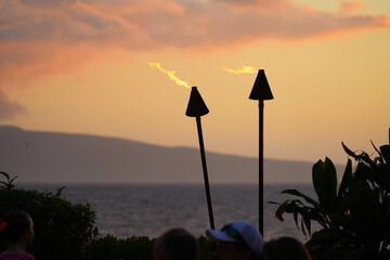 Torches burning in front of the Pacific Ocean at sunset in the resort area of Wailea on the...