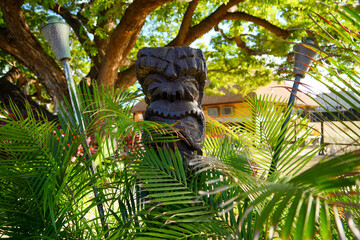 Kapolei, Hawaii / February 23, 2022 : Wooden statue of a tiki god at the Paradise Cove Luau in Ko Olina, a touristic area on the western shore of O'ahu island in Hawaii, United States - obrazy, fototapety, plakaty