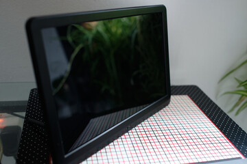 Black Electronic picture frame is standing on a side table with the screen turned off and...