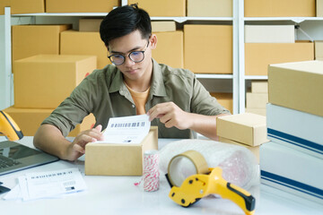 Young entrepreneur packing online order product for shipping.