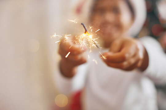Adorable boy dark skin color in festive costume entertaining with Bengali lights