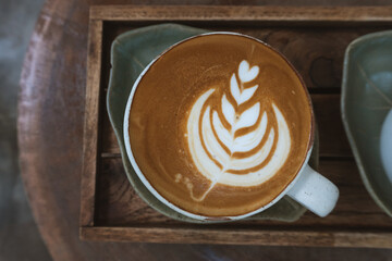 Hot latte in green cup on the wood table