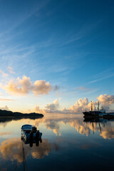 sun rise scene in Palau. The morning sun light reflects on the sea, clouds with orange color.