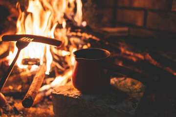Warming up the fire, cozy winter night in the scandinavian cottage house cabin by the fireplace,...