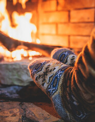 Warming up the fire, cozy winter night in the cabin house by the fireplace, fireplace burns in the...