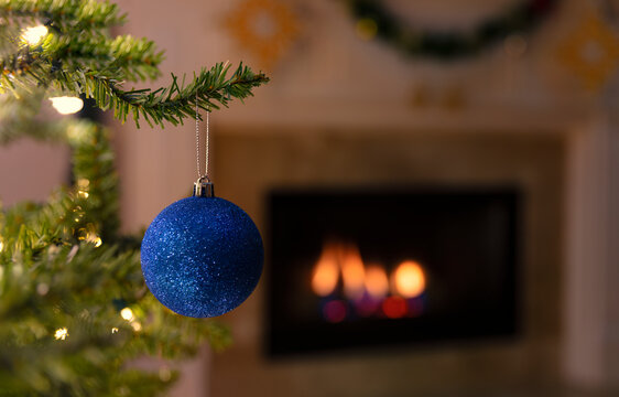 Close up of a single blue Christmas holiday ornament hanging from tree
