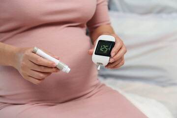 pregnant woman holding glucose meter with result of measurement sugar high level. gestational diabetes concept. - obrazy, fototapety, plakaty