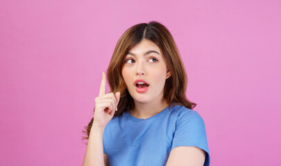 Portrait of excited young woman wearing casual t-shirt thinking and imagination isolated over pink background