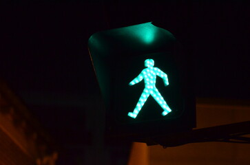 A close look at a green traffic light for pedestrians at night