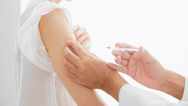 ワクチン接種をするミドル女性　注射イメージ