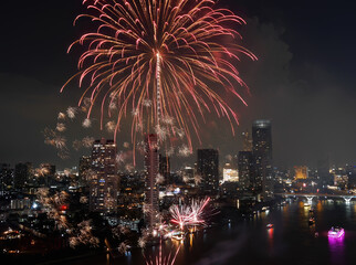 High angle view Fantastic Multicolor Long Exposure shot of Fireworks over Chao Phraya River, Cityscape of Bangkok, Festival, Celebration, Happy New Year, Business Architecture.