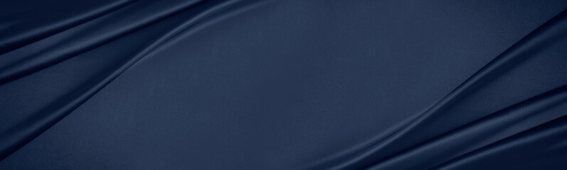 Dark blue silk satin. Soft folds. Fabric. Navy blue luxury background. Space for design.Wavy...