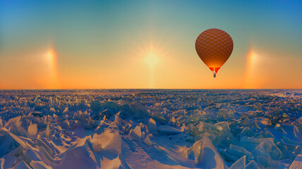 Hot air balloon flying over frozen lake baikal with Amazing Halo - Lake Baikal, Irkutsk region,...