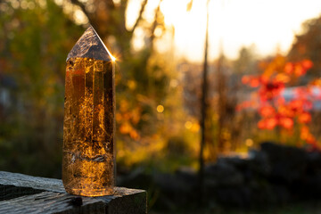 An image of a smoky quartz crystal tower taken in late evening with golden sunlight reflecting off...