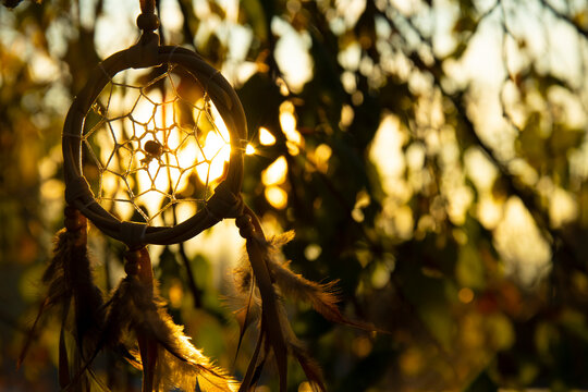 A backlit image of a hand made dream catcher taken at sunset. 