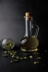 Fototapeta na wymiar olive oil in glass bottle on dark background