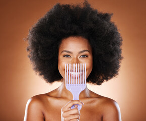 Black woman afro, comb and smile for hair care, style or fashion against a studio background....