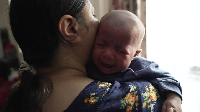 Mother Holding Crying 2 Month Old Baby Over Shoulder To Try And Sooth Him. Slow Motion