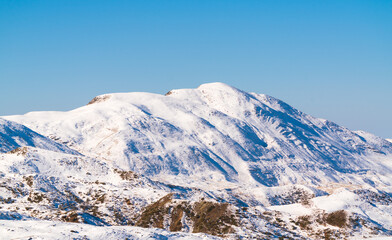 Fototapeta na wymiar Snow covered hmountain peak and blue sky