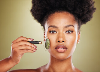Skincare, face roller and black woman in studio portrait with facial massage for natural beauty,...