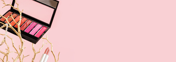 Tender pink feminine makeup tools and accessories. brushes blush lipstick pearls on golden tree branches on candy pink. Birthday beauty cosmetics blogger advert banner concept.
