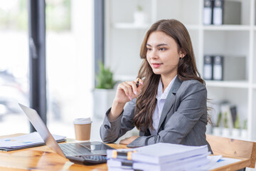 Young business Asian woman Accounting using calculating income-expenditure and analyzing real estate investment data report Financial and tax systems concept.	