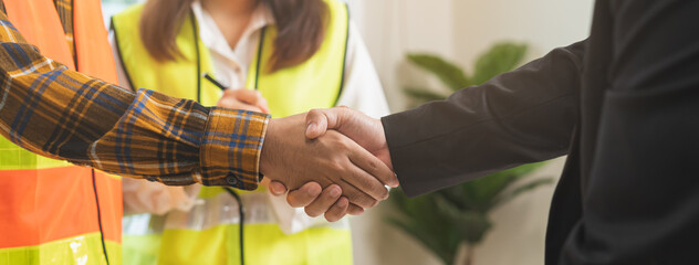 Successful team building, two asian young man builder group use hand handshake together at office...