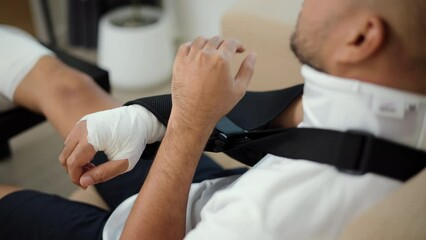 Close-up arm splints, sling support arm of man suffered pain from accident fracture broken bone injury with neck splints collar, leg splints in cast. Social security and health insurance concept.