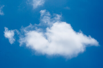 Fototapeta na wymiar White fluffy cumulus clouds on a bright blue sky background.