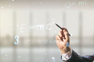 Man hand with pen working with scientific formula illustration on blurred office background,...