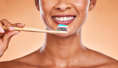 Studio, dental and black woman brushing teeth on orange background. Wellness, oral health or...