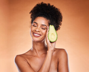 Skincare, wellness and black woman with avocado in studio on brown background for body care....