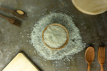 uncooked rice or dry rice. raw rice in wooden bowl with wooden spoon and fork
