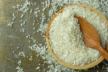 uncooked rice or dry rice. raw rice in wooden bowl with wooden spoon and fork