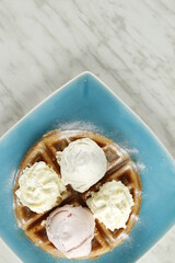 Waffles with ice cream and whipped butter on a plate