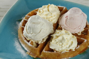 Waffles with ice cream and whipped butter on a plate