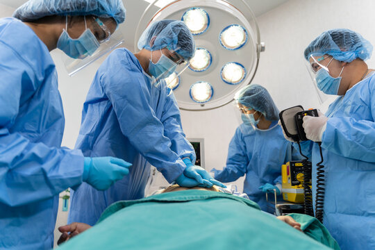 Medical team in Surgical gown help patient to making CPR Cardio Pulmonary Resuscitation in the operation room in hospital