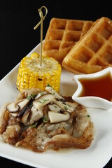 Bacon with mushroom gravy dish with corn, waffles and syrup