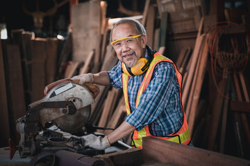 An elderly carpenter works the wood with meticulous care.