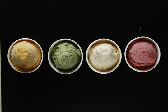 Top shot of four flavors of ice cream on a black background, dramatic lighting