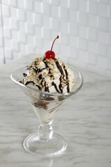 Hot fudge sundae with nuts and cherry on top