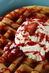 Waffles with strawberries, strawberry syrup and whipped butter