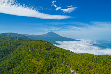 Aerial photo of mount Teide in the distance above the clouds. Volcano in Teide national park in Tenerife island, Spain.