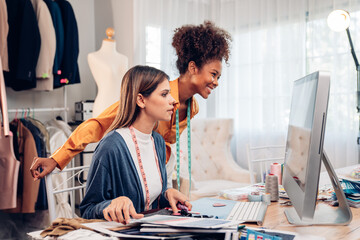 Fototapeta premium Fashion design concept, young stylish woman fashion designer working in studio office, small business owner creating new fashion design cloth in atelier.