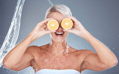 Water splash, fruit and senior skincare of a woman holding orange for vitamin c and skin glow....