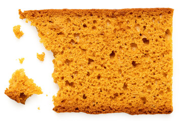 Partially eaten slice of spiced honey cake with crumbs isolated on white from above.