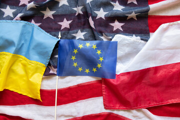 Flags of America, Ukraine, Poland, the European Union lie on the table as a background, friendship...