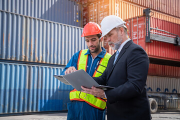 Container yard manager with safety hat talking to foreman about the goods inside the warehouse, Logistics business, Import and export concept.