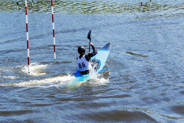 Athlete on a kayak during a rowing slalom competition.