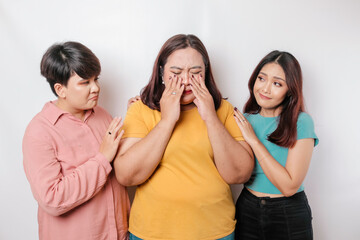 A portrait of three friends looking sad crying wiped her tears and hug each other, isolated white background